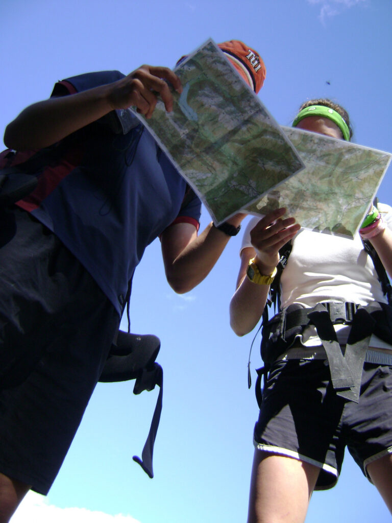 Two hikers in shorts looking at a trail map.